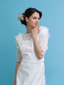 Portrait of beautiful young women in wedding dress isolated on a cyan background