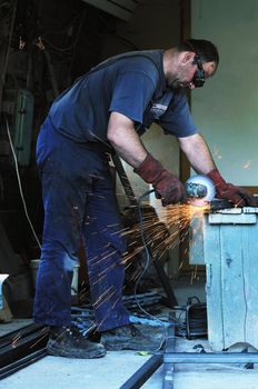 industry worker cut steel with spinning machine and spark