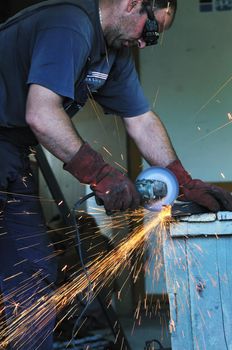 industry worker cut steel with spinning machine and spark