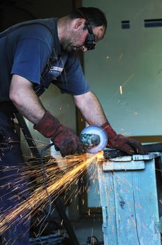 industry worker cut steel with spinning machine and spark