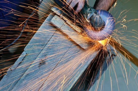 industry worker cut steel with spinning machine and spark