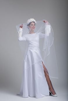 Portrait of beautiful young bride in a wedding dress with a veil isolated on a white background