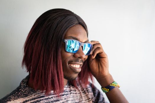 Funny black boy with long hair and sunglasses laughing