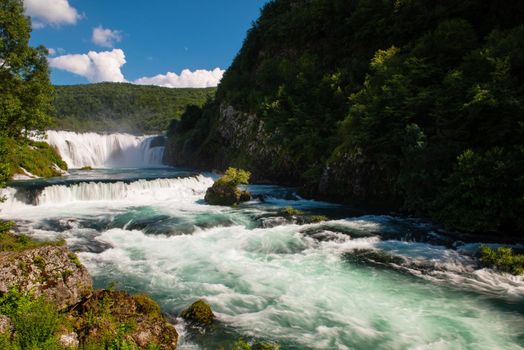 waterfall in beautiful nature with crystal clear water on wild river una in bosnia and herzegovina at sunny summer day