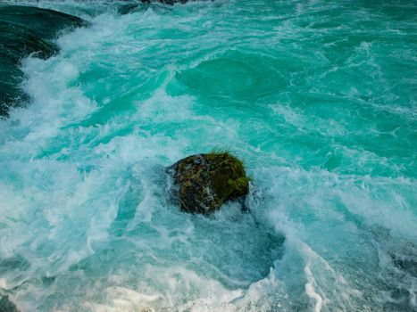 single stone in wild river landscape  long exposure photo representing liquid flow concept