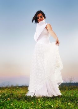happy young beautiful bride after wedding ceremony event have fun on meadow in fashionable wedding dress