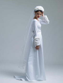 Portrait of beautiful young bride in a wedding dress with a veil isolated on a white background