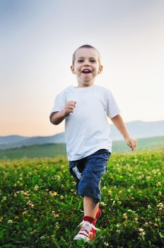 little happy child play with windmil toy and have ve fun while running on beautiful meadow at sunset