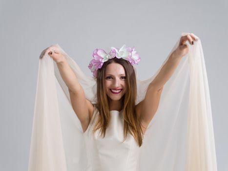 Portrait of beautiful young bride in a wedding dress with a veil isolated on a white background