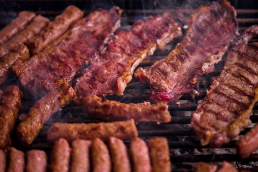 Assorted delicious grilled meat over the coals on barbecue