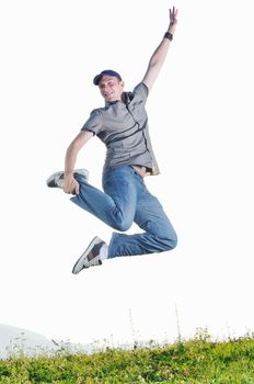 happy young man jumping in air from joy at sunset on beautiful meadow