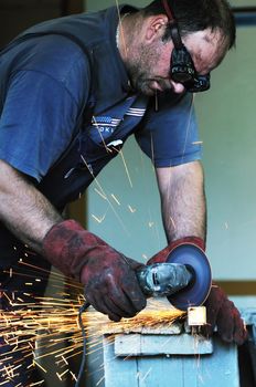 industry worker cut steel with spinning machine and spark