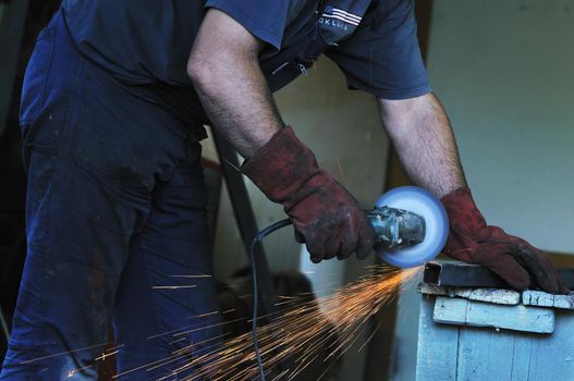 industry worker cut steel with spinning machine and spark