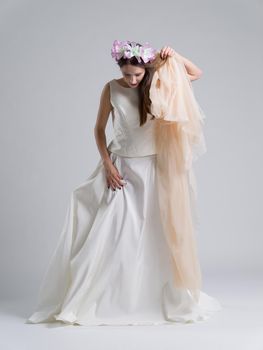 Portrait of beautiful young bride in a wedding dress with a veil isolated on a white background