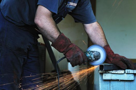 industry worker cut steel with spinning machine and spark