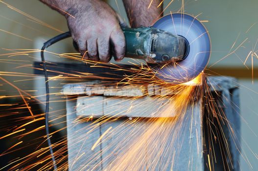 industry worker cut steel with spinning machine and spark