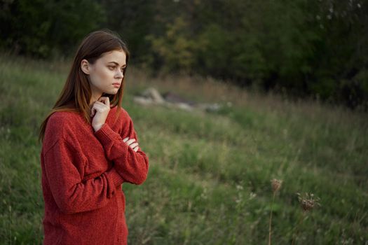 woman in a red sweater outdoors in a field walk. High quality photo