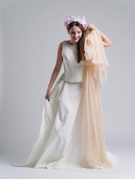 Portrait of beautiful young bride in a wedding dress with a veil isolated on a white background