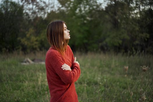 woman in a red sweater outdoors in the field nature rest. High quality photo