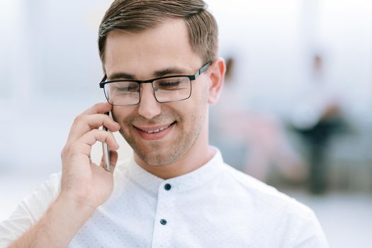 close up.smiling businessman talking on his smartphone . business concept