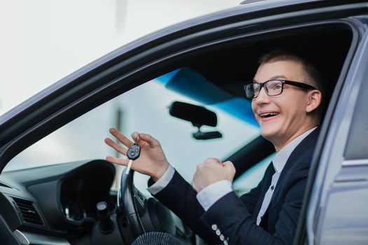 Close up. happy businessman holding keys to his new car