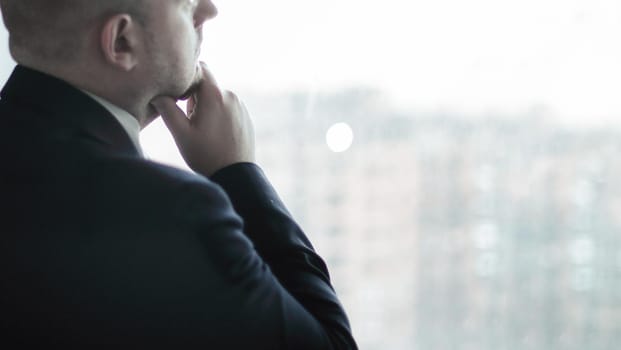 closeup. thoughtful businessman looking in the office window