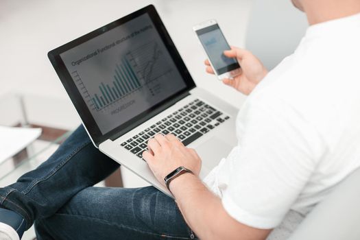 close up. businessman using smartphone and laptop. people and technology