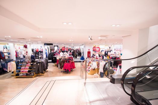 people in luxury and fashionable brand new interior of clothing store
