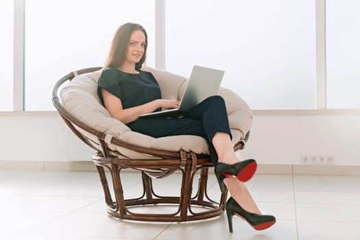 business woman working on a laptop sitting in a comfortable chair.photo with copy space