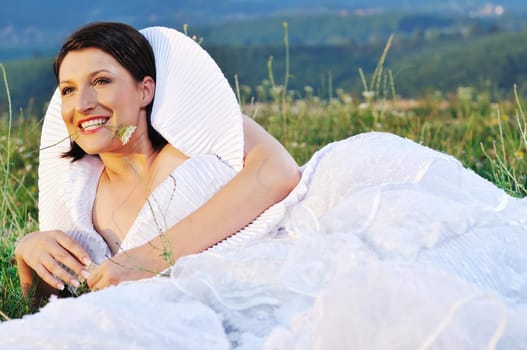 happy young beautiful bride after wedding ceremony event have fun on meadow in fashionable wedding dress