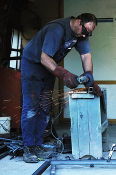 industry worker cut steel with spinning machine and spark