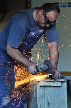 industry worker cut steel with spinning machine and spark