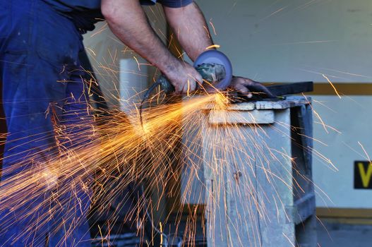 industry worker cut steel with spinning machine and spark