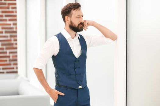 thoughtful businessman standing near the office window.business concept