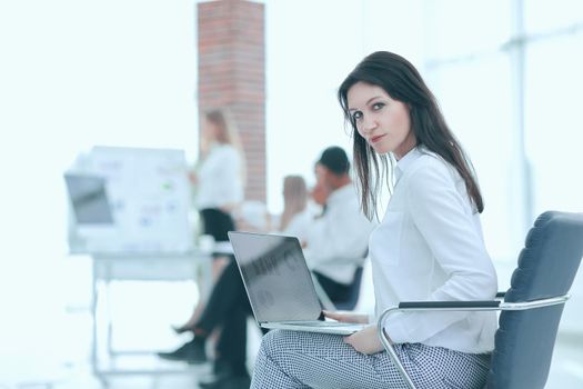 smiling business woman with laptop on blurred background office.