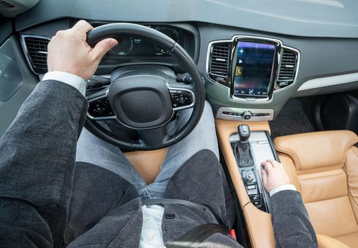 Funny wide angle of a male driver in luxury car