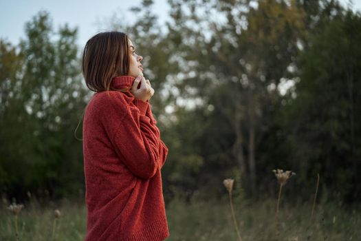 woman outdoors in a red sweater cool nature. High quality photo