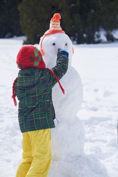 little boy making snowman
