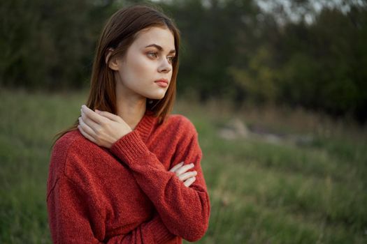 woman in a red sweater outdoors in a field walk. High quality photo