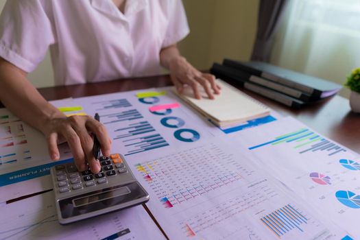 An accountant or businesswoman is calculating statistical graphs about Finance, Company Accounts, Taxes, Income, or Loss.