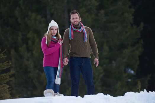 happy young  couple having fun and walking in snow shoes. Romantic winter relaxation scene