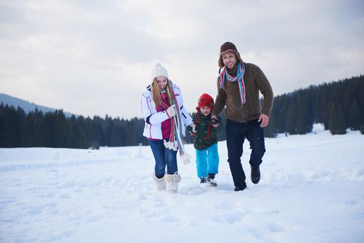 happy young  family playing in fresh snow  at beautiful sunny winter day outdoor in nature