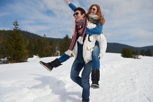 romantic winter  scene, happy young couple having fun on fresh show on winter vacatio, mountain nature landscape