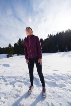 yougn woman jogging outdoor on snow in forest, healthy winter lifestyle and recreation