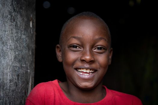 African black boy portrait standing near his poor house alone