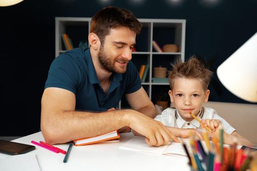 Father helping his little son with school homework close up
