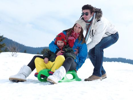 Winter playing, fun, snow and family portrait  sledding at winter time