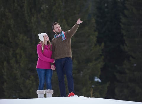 happy young  couple having fun and walking in snow shoes outdoor in nature at beautiful winter day. Health sport and relaxation