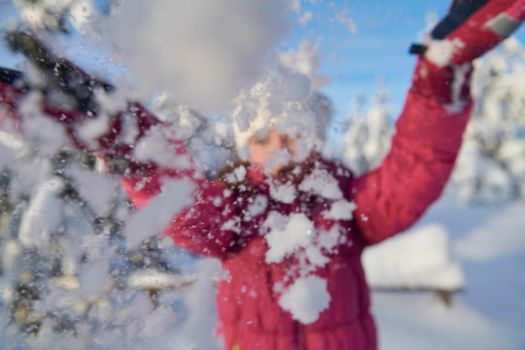 little girl having fun  throwing fresh snow at beautiful sunny winter day