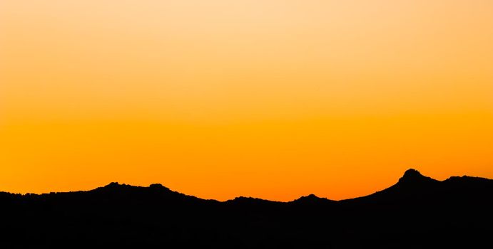 Background from a beautiful colorful sunset with the silhouette of the mountains. High quality photo